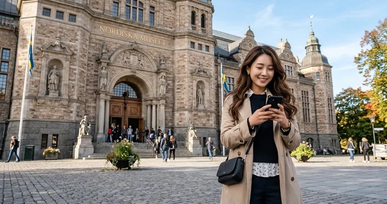 A person using a smartphone outside a large historic building.